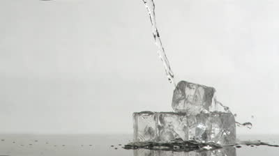 stock-footage-trickle-of-water-in-a-super-slow-motion-flowing-on-ice-cubes-against-a-grey-background